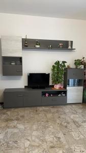 a living room with a entertainment center with a tv at Thind house in Brescia