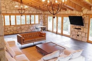 a living room with a couch and a flat screen tv at Finca en el Bosque Huasca de Ocampo con Alberca in Huasca de Ocampo