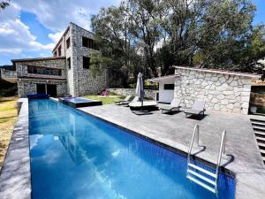 a swimming pool in front of a house at Finca en el Bosque Huasca de Ocampo con Alberca in Huasca de Ocampo