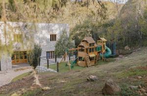 a house with a playground in front of a house at Finca en el Bosque Huasca de Ocampo con Alberca in Huasca de Ocampo