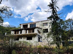 an old stone house on a hill with trees at Finca en el Bosque Huasca de Ocampo con Alberca in Huasca de Ocampo +20 photos