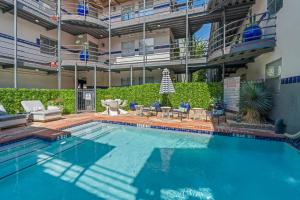 a large swimming pool with chairs and a building at Spacious Austin Loft 4BR Sleeps 12 in Austin
