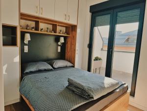 a bedroom with a bed in a room with a window at "Dolce Vita" Loft in Tuzla