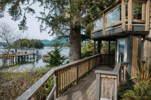 a house on the water with a tree at The Shoreline Tofino in Tofino