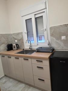 a kitchen with a sink and a keyboard on a counter at BLV Apartments in Tsoukalades +20 photos