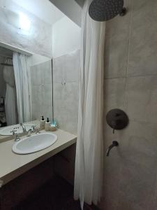 a bathroom with a sink and a shower curtain at La Esquina in Esquel