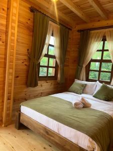 a bedroom with a large bed in a log cabin at Derya Dağ Evleri in Çamlıhemşin