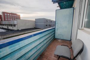 a chair sitting on the balcony of a building at Rhodopi Hotel Plovdiv in Plovdiv