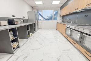 a large kitchen with white marble floors and counters at Rhodopi Hotel Plovdiv in Plovdiv