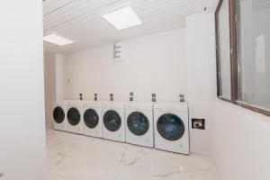 a row of washing machines in a white room at Rhodopi Hotel Plovdiv in Plovdiv