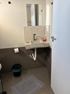 a bathroom with a sink and a mirror at Apartamento casa da Lu 102 in Primavera do Leste