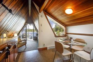 a kitchen with wooden ceilings and a table and chairs at The Shoreline Tofino in Tofino
