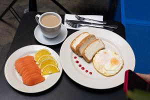 a table with two plates of food and a cup of coffee at Hostal Joy Calle 85 in Bogotá