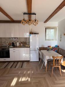 a kitchen with a table and a white refrigerator at Kuća Tajna Banja Vrujci in Mionica