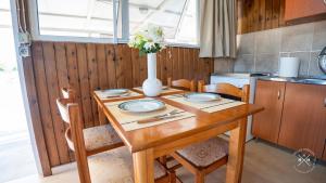 a wooden table with plates and a vase of flowers on it at Casa fig Crete in Chania +17 photos