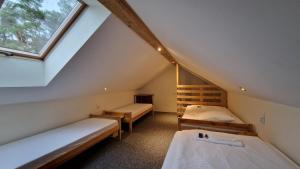 ein Dachzimmer mit zwei Betten und einem Fenster in der Unterkunft Na Molo in Głębokie