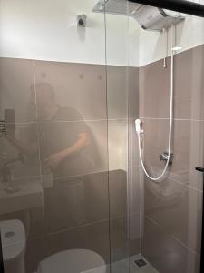 a bathroom with a glass shower with a toilet at Apartamentos casa da Lu 101 in Primavera do Leste