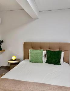 a bedroom with a white bed with green pillows at Aegean Horizon Seafront Luxury Villa Plomari Garden Level in Trýgonas