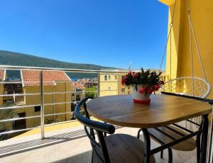 a table and chairs on a balcony with a view at LouAdria Apartments in Đenovići