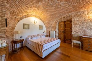 a bedroom with a bed and a brick wall at Domus Sa Corbula in Oristano +50 photos