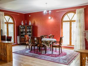 a dining room with red walls and a table and chairs at guest hause "villa" in Dushetʼi