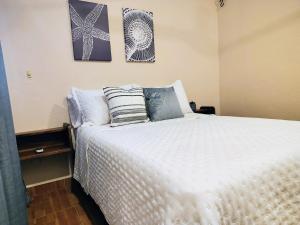 a bedroom with a white bed with pillows on it at Comfortable apartment close to beaches and plazas in Santa Cruz Huatulco