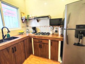 a kitchen with wooden cabinets and a stainless steel refrigerator at Comfortable apartment close to beaches and plazas in Santa Cruz Huatulco