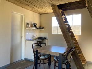 a kitchen with a table and chairs and a staircase at Paraitinga Glamping in São Luiz do Paraitinga