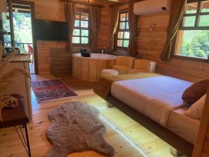 a bedroom with a large bed and a bath room at Derya Dağ Evleri in Çamlıhemşin