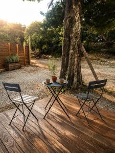 a table and two chairs on a deck with a tree at Chambre cosy in Viols en Laval
