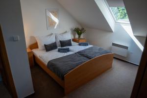 a bedroom with a large bed in a attic at Penzion Mítkov in Brandýs nad Orlicí