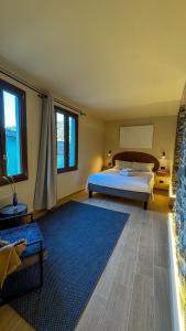 a bedroom with a bed and a blue rug at Nervia Rooms by Talking Stones in Dolceacqua