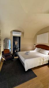 a bedroom with a large bed and a chair at Nervia Rooms by Talking Stones in Dolceacqua