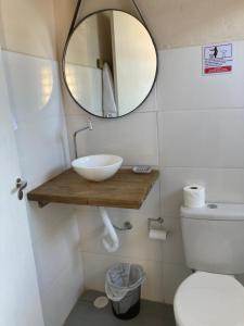 a bathroom with a sink and a mirror and a toilet at Paraitinga Glamping in São Luiz do Paraitinga