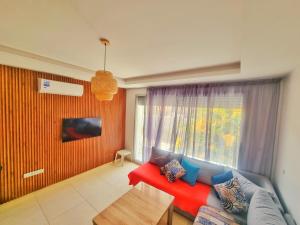 a living room with a red couch and a window at Cozy apartment adana in Aourir