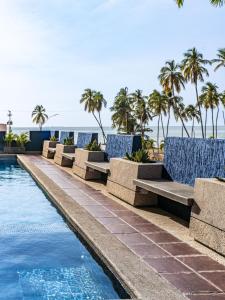 a row of blue chairs next to a swimming pool at Hotel Puerto Playa Suites in El Morro de Barcelona +37 photos