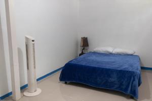 a bedroom with a bed with a blue blanket and a heater at Cozy Apartment in Minca in Minca