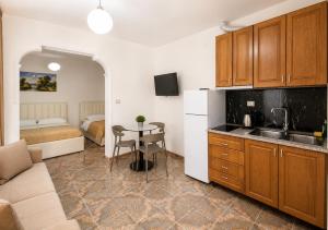 a kitchen with a table and a room with a bed at Villa Arli&Eris in Vlorë