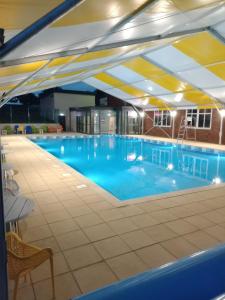 a large swimming pool with blue water in a building at 75 Orchard Mount, 3 bed luxury caravan Skirlington- sleeps 6 in Hornsea