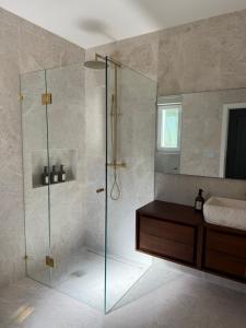 a bathroom with a glass shower and a sink at Villa Ljeto in Pupnatska Luka +26 photos