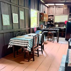 a dining room with a table and chairs and a kitchen at La Cabaña de Don Tavo in Roble