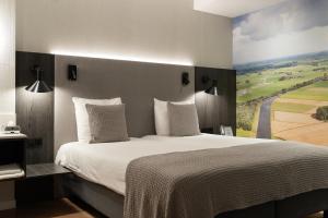 a bedroom with a large bed with a painting on the wall at Mercure Hotel Schiphol Terminal in Schiphol +9 photos