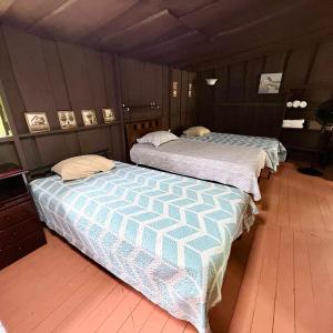 two beds sitting next to each other in a room at La Cabaña de Don Tavo in Roble
