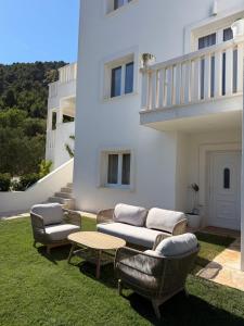 a patio with a couch and chairs and a table at Villa Ljeto in Pupnatska Luka