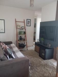 a living room with a couch and a flat screen tv at Small family apartment in Sao Sebastiao