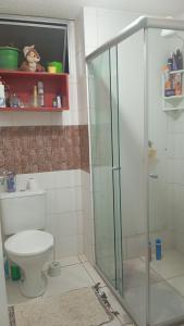 a bathroom with a toilet and a glass shower at Small family apartment in Sao Sebastiao