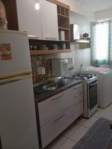 a kitchen with a sink and a stove and a refrigerator at Small family apartment in Sao Sebastiao