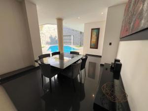 a dining room with a glass table and chairs at Espectacular, Casa Vacacional Jpol in Cali
