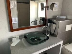 a bathroom with a green sink and a mirror at Berggasthof Immenstein in Bühl