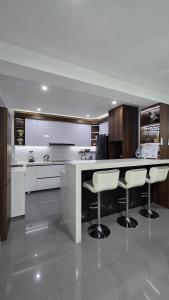 a kitchen with a counter and two bar stools at 2 departamento ejecutivo capacidad 08 in Tacna